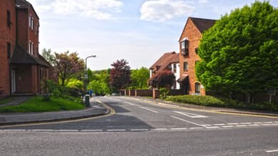 Commainge Close in Warwick, a road between red-brick flats leading down from Theatre Street, with a blue parking sign by the pavement