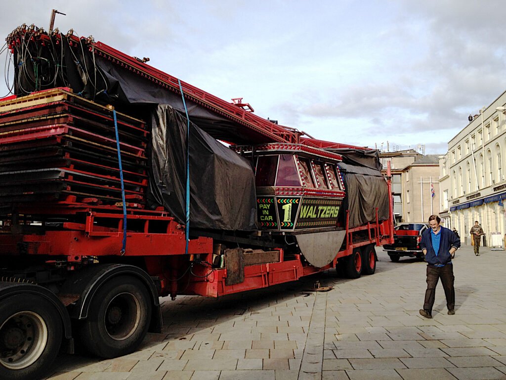 A lorry carrying the waltzers ride into Warwick Market Place for the Mop fair